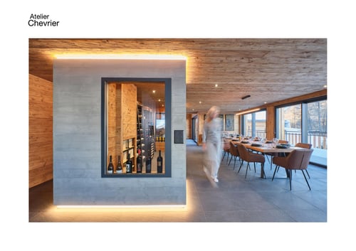 Salle à manger avec cave à vin en béton apparent dans une maison individuelle en bois à La Sage, Évolène, Val d’Hérens, Valais.