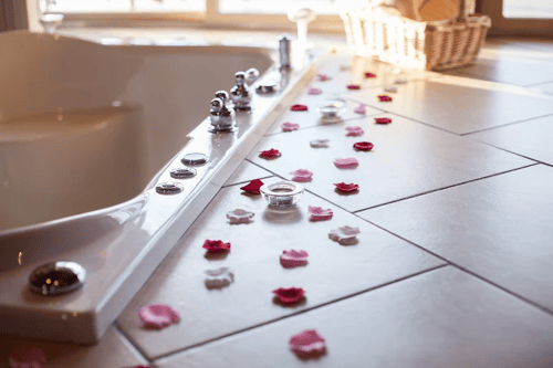 Sunken whirlpool tub with rose petals scattered near the edge