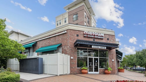 A brick building with a green awning and a sign that says "Midtown" on it at Midtown at Camp Springs in Camp Springs, MD, 20746