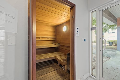 A sauna with wooden walls and benches is open to the outside at Coastline Apartments in Fort Walton Beach, FL, 32547