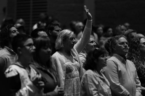 A group of people singing praise worship music at church.