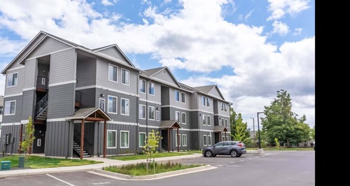 A grey apartment building with a car parked in front at Marcola Apartment Homes, Forest Grove, OR, 97477