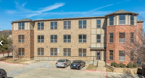 A red brick building with a white trim around the windows at City Place Apartments Denton, TX 76201