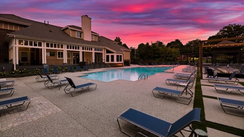 Swimming pool with clubhouse in the background at sunset at Butternut Ridge, North Olmsted, OH