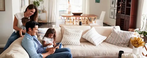 young-hispanic-family-sitting-on-sofa-reading-a-book