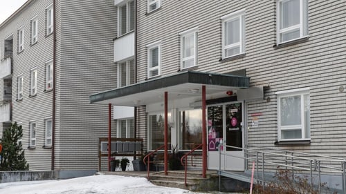 Sisäänkäynti kolmikerroksiseen rakennukseen, jossa sijaitsee useampi toimipiste.