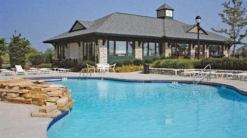 Swimming pool with chairs and umbrellas and trees at Four Bridges, Ohio