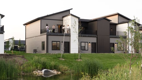 Rialto Townhomes building with a green space and lake in front of it, Waukee, IA