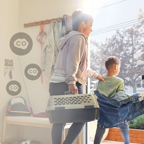 A mom and her son evacuate their home while carrying a pet carrier.