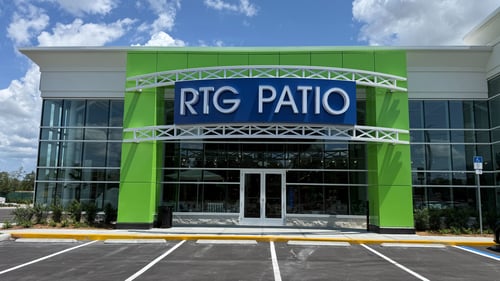 Front exterior of an RTG Patio store with green entrance accents and glass façade.