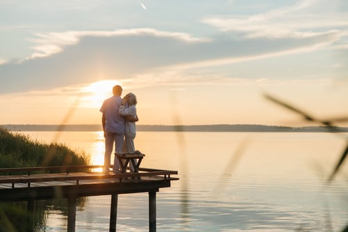 couple at the end of a dock during sunset