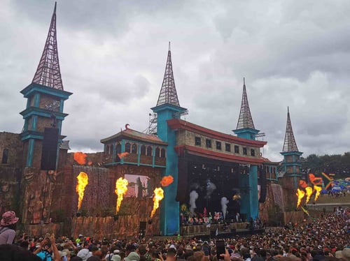 hampshire festival stage with pyrotechnics and large crowd on a cloudy day