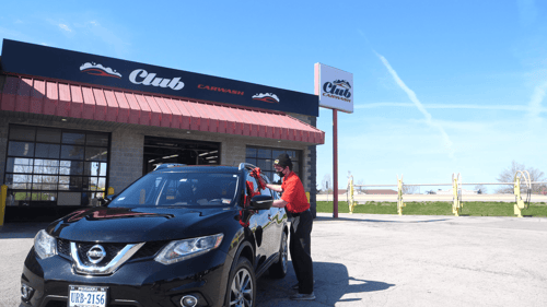 Employee Wiping Down Vehicle in the Front of the Columbia, Missouri Club Car Wash