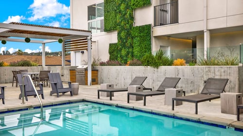 a swimming pool with lounge chairs next to a building at the perch, Los Angeles, CA 90065