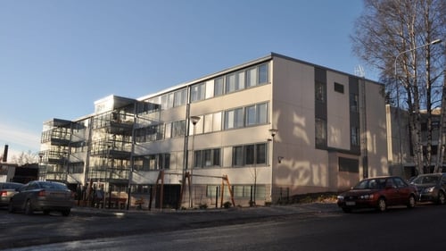 Ulkokuva Kornetista. Rakennus on vaaleaa kiveä ja siinä on kolme kerrosta. Pihalla on keinuja.