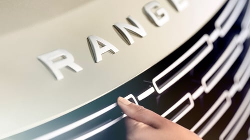 Close-up of Range Rover wordmark on vehicle.