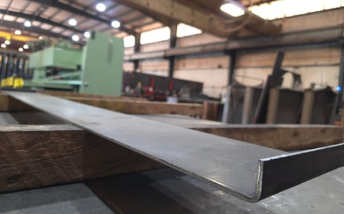 Custom steel plate fabrication inside Ozark Mountain Steel shop showing cut structural metal ready for installation