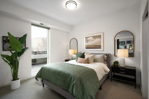 A bedroom with a bed, nightstand, and a plant at The Flats at West End in St. Louis Park, MN 55416