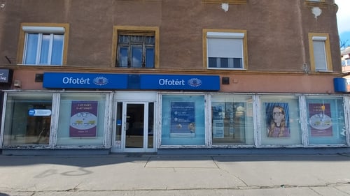 Ofotért üzlet homlokzata Budapesten, a Bosnyák téren, világos kirakattal és utcafronti bejárattal.