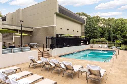 Apartment building with a swimming pool, modern architecture, and landscaped surroundings at The Tarnhill Apartments in Bloomington, MN