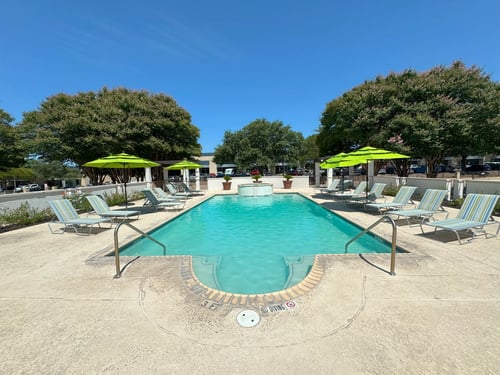 Resort style pool with fountain and lounge seating at La Calera Apartments, San Antonio, Texas