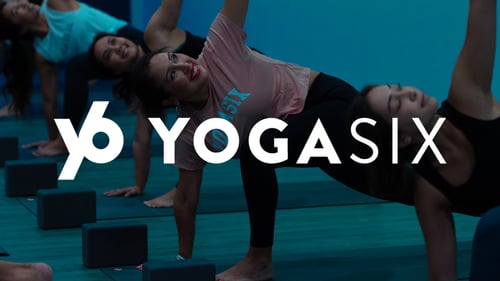 People smiling and enjoying yoga at YogaSix.