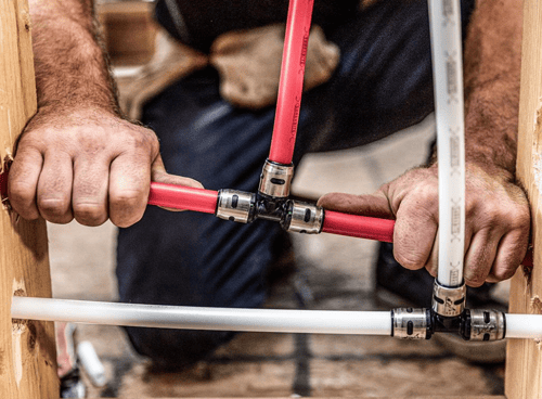 Plumber installing residential PEX water supply lines