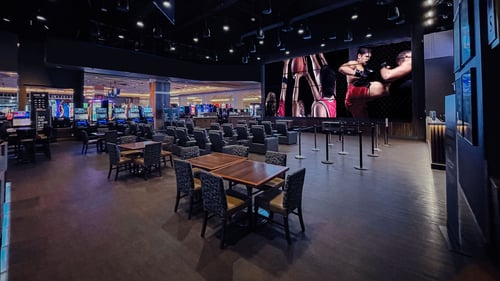 Seating area and large screen inside Caesars Sportsbook.