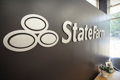 Black wall with silver State Farm sign on it