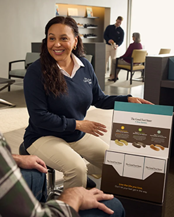 female good feet store employee talking to male customer about arch support system