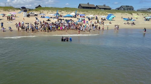 Church of the Outer Banks meet on the beach for a baptism in the ocean.