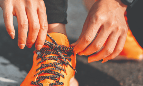 person tying running shoes