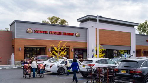 People walking with shopping carts in front of North Shore Farms