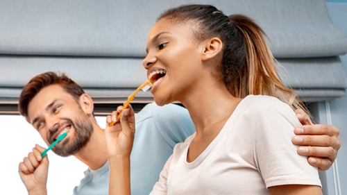 Two people brushing their teeth