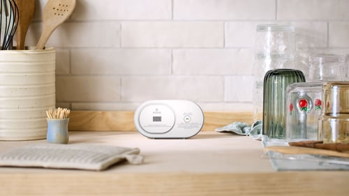 A CO alarm sits on a kitchen counter.