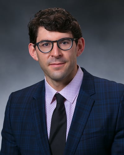 Dr. Peter White in front of a gray background.