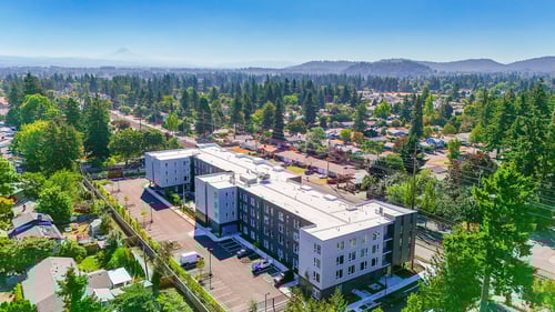 A large white building with a parking lot in front of it.at Terracina Vista, Portland, OR
