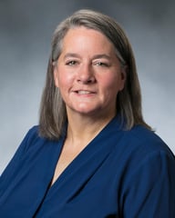 Dr. Elizabeth Day smiling in front of a gray background.