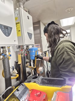 bluefrog Plumber Shae Petterson inspecting dual tankless water heater installation