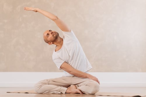 Yogalehrer "Kai" bei sitzender Seitdehnung im KarmaConcepts.Yoga Studio Münster