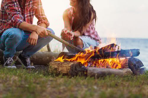 Couple sitting beside a campfire.