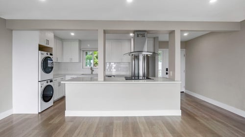 A modern kitchen with a white countertop and wooden flooring at Ocean Edge at Laguna Beach