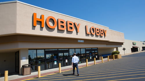 Man dressed business casual walking towards front entrance of Hobby Lobby at Williamson Square shopping center