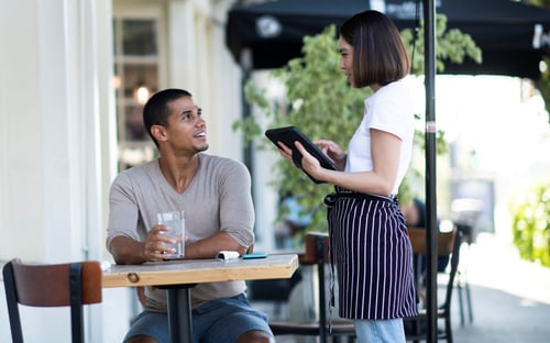 Man using Wi-Fi at a table outside a cafe in Denver, CO