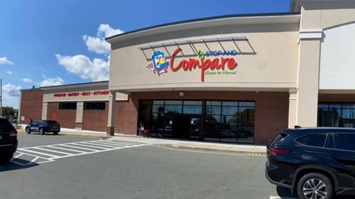 End of Black SUV parked in front of Stop and Compare