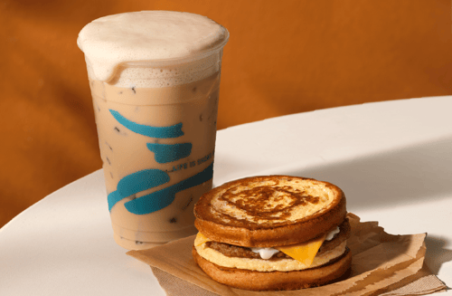 Seasonal iced coffee and a hot breakfast sandwich on a tabletop.
