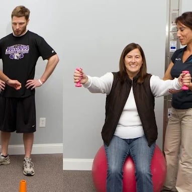 Eastpointe Integrated Healthcare client doing simple exercises with dumbbells on a yoga ball.