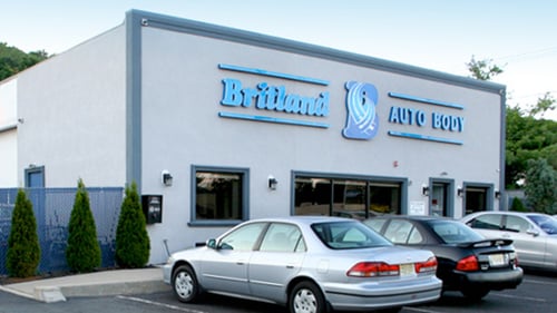 Front view of Britland Auto Body’s Green Brook location featuring the building exterior, customer parking area, and company signage with BritlandAutoBody.com and (732) 752-5522 displayed.