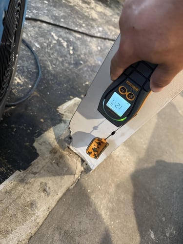 Using a moisture meter to determine if a wall is wet underneath the surface