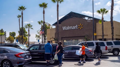 Family packing their car with palm trees in the Walmart parking lot